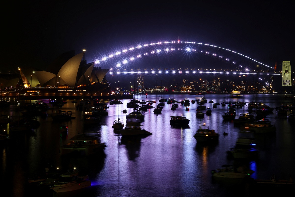 Podul Sydney Harbour Bridge este iluminat în alb în timpul „Momentului de unitate”, o pauză de un minut pentru a comemora tragicul incident armat care a avut loc în timpul sărbătorii evreiești Hanukkah la Bondi Beach, pe 14 decembrie, în timpul festivităților de Revelion, în Sydney, Australia, pe 31 decembrie 2025.